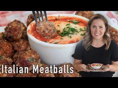 a woman is holding a plate with meatballs on it and the words italian meatballs