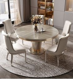 a round dining table with white chairs around it