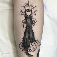 a black and white photo of a clock tower tattoo on the right leg with clouds around it