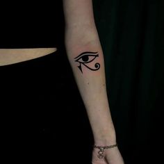 a woman's arm with an evil eye tattoo on the left side of her hand