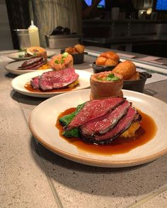 three plates with food on them sitting on a counter