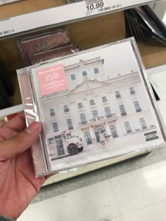 a person holding up a cd in front of a store