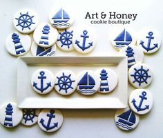 some cookies with blue and white designs on them are arranged in the shape of boats, ships, and anchors