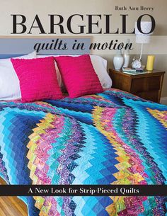 a bed with colorful quilts and pillows on it