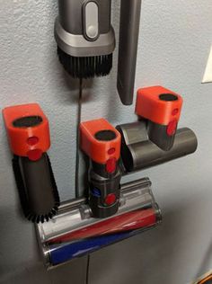 three red and black objects are attached to the wall in this office area, with a hair dryer nearby