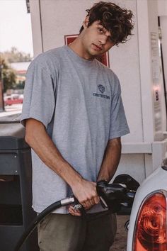 a man filling up his car at a gas station