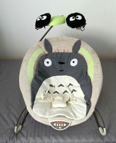 a baby bouncer with two stuffed animals on it's back and the words diy, totoro - themed baby bouncer