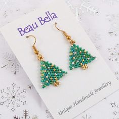 These fun Christmas tree earrings have been handmade using glass seed beads in Christmassy green and gold shades.  They would be ideal for a Christmas party or would make a lovely festive gift or stocking stuffer. I've hand stitched the earrings using shiny green, silver and gold coloured Miyuki glass delica seed beads.  The tree measures about 2.5 cm long by 2 cm wide.  The drop length from the top of the hook is approximately 4 cm. The ear hooks are gold plated. The earrings will be packaged o Handmade Beaded Earrings For Christmas Crafting, Handmade Holiday Beaded Earrings With Round Beads, Handmade Beaded Earrings For Holiday, Handmade Round Beaded Earrings For Holiday, Handmade Green Beaded Christmas Earrings, Handmade Green Beaded Earrings For Christmas, Holiday Green Handmade Beaded Earrings, Handmade Green Beaded Earrings For Holiday, Green Gold Christmas Tree