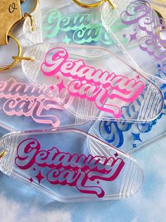 six clear plastic key chains with colorful lettering on them