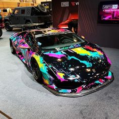 a colorful car is on display at an auto show