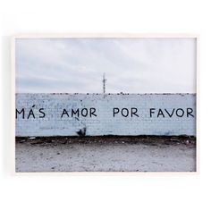 a white brick wall with the words mas amor porfavor written on it