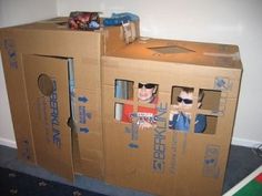 two cardboard boxes with the faces of people in them and one has sunglasses on his head