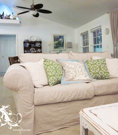 a living room filled with furniture and a ceiling fan