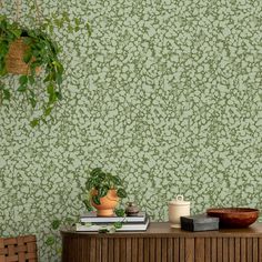 a room with green wallpaper and a plant on the side table in front of it