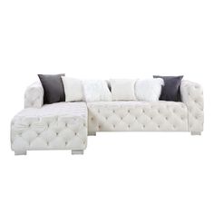 a white couch and ottoman with pillows on it