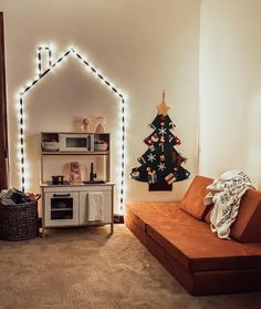 a living room filled with furniture and a christmas tree on the wall next to it