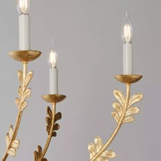 two gold leaf candelabra lights with white candles