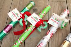 several wrapped christmas presents sitting on top of a wooden table next to an empty bottle