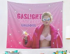 a pink wall tapestry with a woman holding a lit candle in her right hand and the words gaslight gatekeeper on it