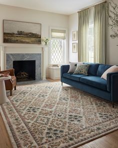 a living room filled with furniture and a fire place under a painting on the wall