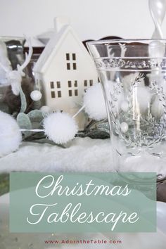 christmas tablescape with white pom poms and silverware in glass vases