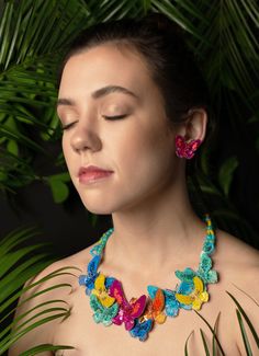 Statement necklace made of overlapping butterfly appliqués, with dyed jade bead and tiny sequin scalloped beading at back. Each butterfly appliqué is covered in tiny sequins, metallic coiled wires, and micro-cut beads, with feather details on wings. Front bib section measures about 7-1/2” wide and 2-1/2” long at center front. Necklace length is about 17-1/2” long, and extender chain is 1-1/2” long. Lobster claw closure at back. Pokemon Jewelry, Beadwork Necklace, Fabric Necklace, Handmade Jewelry Tutorials, Beaded Statement Necklace, Butterfly Jewelry, Fancy Jewelry, Jade Beads, Butterfly Pendant