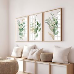 three framed paintings hang on the wall above a bench with pillows and wicker basket