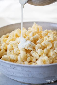 a bowl filled with macaroni and cheese being drizzled over it