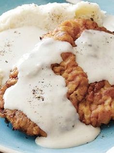 fried chicken with gravy and mashed potatoes on a blue plate