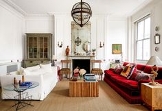 a living room filled with furniture and a fire place in front of a mirror on the wall