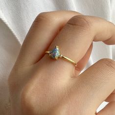 Blue opal ring is a new trend minimal product that you can use every day with a unique stone selected by ISEA Fine Jewelry. ➤ Ring Details * 14k / 18k Yellow Gold or Yellow Sterling Silver * Gold Color Options; 14K / 18k White, Yellow, Rose Gold * Sterling Silver Color Options; Yellow, Rose, White * Band Width: 2.30 mm * Thickness: 1.80 mm ➤ Gem Details * Gemstone 1 : Opal * Gem color: Blue * Gem width: 4 millimeter * Gem length: 6 millimeter * Cut Type: Pear * Gemstone 2 : Diamond * Diamond Carat: 0.05 * 2 * Cut Type: Round * Ready to Ship 3-5 Business Days 💍 ISEA Jewels' pieces are handcrafted by 10-15 years of experienced craftsmen and made to order in a very short time. 🎁 All pieces come in a quality and hygienic suede gift box enclosed in a pouch. 🌎 Our products arrive worldwide wi Modern Yellow Gold Opal Ring Gift, Minimalist Opal Birthstone Ring, Modern Gold Opal Rings, Modern Opal Jewelry For Anniversary, Modern Pear-shaped Rings As Gift, Gold Opal Birthstone Ring Minimalist Style, Teardrop Opal Promise Ring Fine Jewelry, Teardrop Opal Promise Ring In Fine Jewelry Style, Minimalist Opal Rings With Birthstone