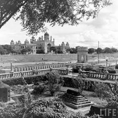 an old black and white photo of a large building in the middle of a park