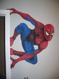 a spider man mural on the side of a wall in a child's room