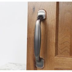 a door handle on a wooden door with white walls in the background and a marble floor