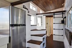 a kitchen area with a refrigerator and stairs