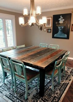 a dining room table with six chairs and a rug on the floor in front of it