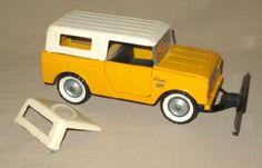 a yellow and white toy truck sitting on top of a table next to a pair of scissors