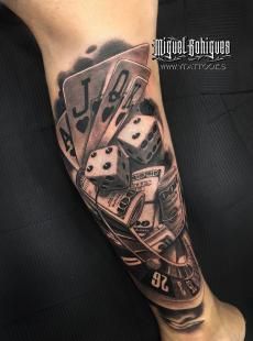 a man's leg with some dice and playing cards on it