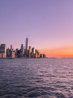 the city skyline is seen from across the water at sunset in this photo taken on a boat