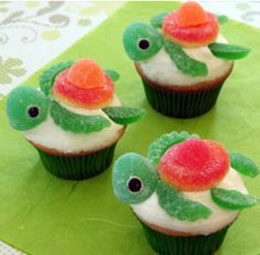 three cupcakes with white frosting and red flowers on them, sitting on top of a green napkin