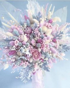 a bridal bouquet with pink and white flowers on blue background in soft light tones