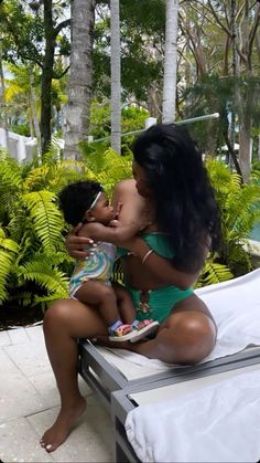 a woman in a green bathing suit holding a baby