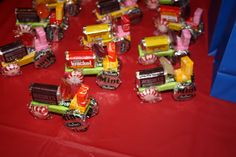 a table topped with lots of candy bars and candies on top of red cloth