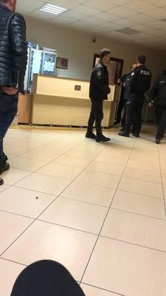 several police officers are standing around in the lobby with their backs turned to the camera