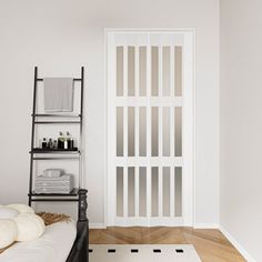 an empty room with a white door and shelves on the wall next to a bed