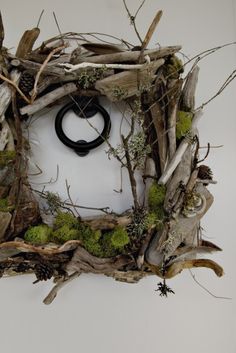 a wreath made out of driftwood and branches with a black ring in the center