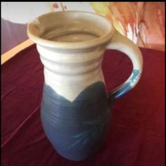 a blue and white vase sitting on top of a red tablecloth covered table cloth