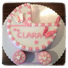 a cake that is shaped like a baby's carriage with the name clara on it