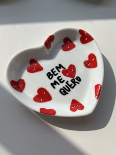 a heart shaped dish with red hearts on it that says be me, guk?