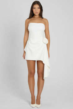 Cut from a opaque, soft and breathable fabric that moves with you, our Rosette Strapless Mini Dress is unlike any other. This white mini dress features a strapless neckline and a bodycon fit that skims down to a mini length. Featuring an asymmetrical hemline in a flowy ruffle design it's complimented by a rosette flower detailing at the hip making it the perfect transitional dress for any day to night look. Flirty White Mini Dress With Straight Neckline, White Mini Dress With Straight Neckline For Cocktail, White Bodycon Mini Dress With Straight Neckline, White Fitted Strapless Mini Dress, White Mini Length Strapless Dress For Cocktail, White Strapless Mini Dress For Cocktail, White Mini Strapless Dress For Cocktail, Rosette Flower, Ruffle Design